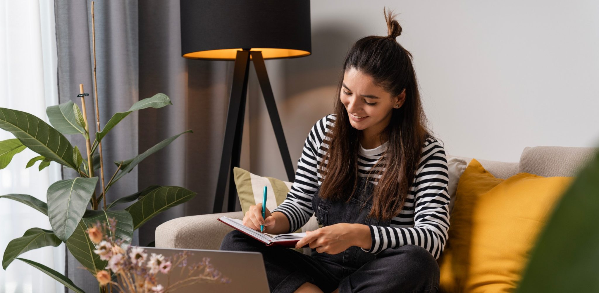 Young female is studying at home on a couch