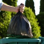 trash bag being placed in bin