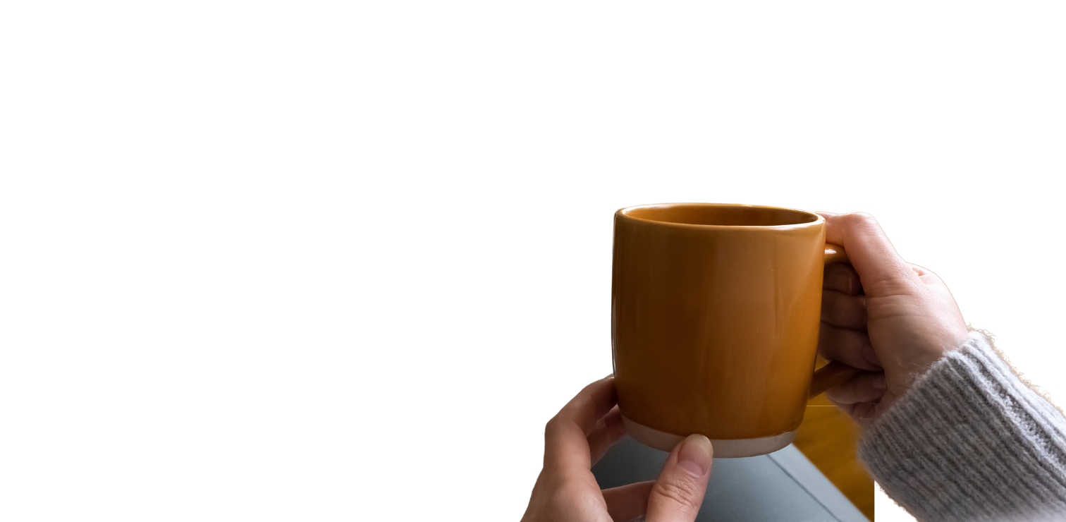person relaxing on a couch with a cup of coffee
