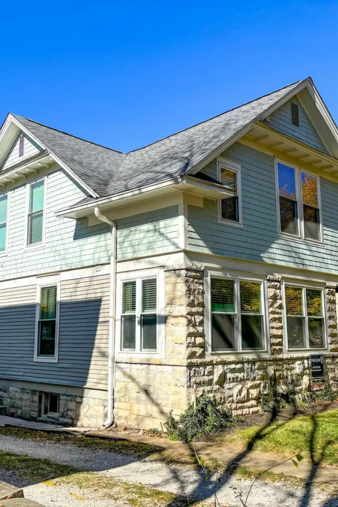 Two-story house with blue siding and stone facade